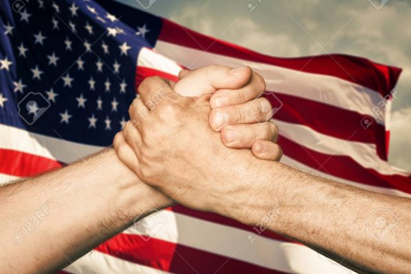 Patriotic concept. Handshaking. The USA flag and shaking hands of two male people