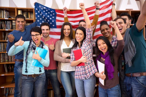 Group of happy students holding American flag and presenting their country
